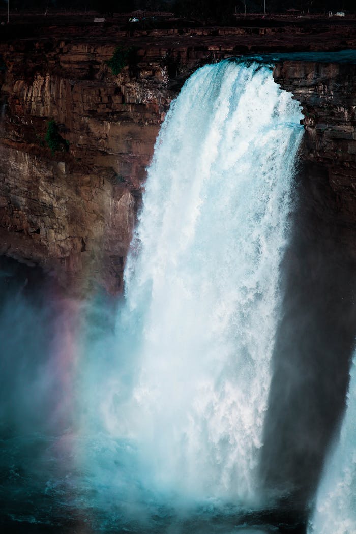 services-04 Experience the breathtaking beauty of a waterfall cascading over rugged cliffs into a misty pool below.